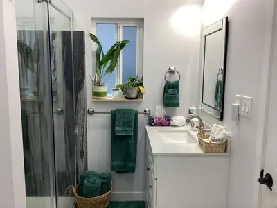 a white bathroom with a shower and a sink at The Cozy Nook in Grand Forks