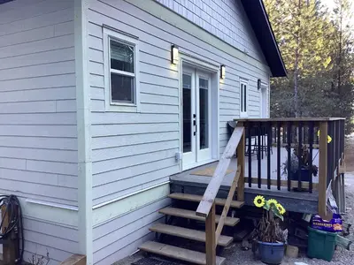 a house with a wooden staircase leading to a porch at The Cozy Nook in Grand Forks