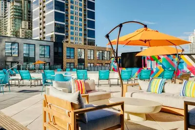 a patio with chairs and tables and an umbrella at Simple Minimalist Condo For Busy Students or Professionals in Calgary