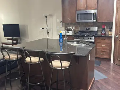 a kitchen with a counter with four bar stools at Peace Home in Calgary