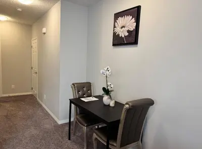 a dining room with a black table and chairs at Quiet Comfortable 1-Bedroom in Calgary