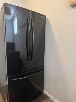 a stainless steel refrigerator in a kitchen at Quiet Comfortable 1-Bedroom in Calgary