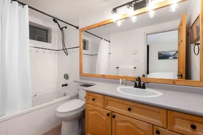 a bathroom with a sink and a toilet and a mirror at Glen Eagles by Whistler Premier in Whistler