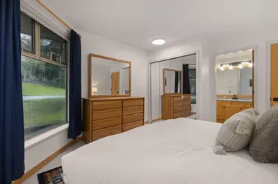a bedroom with a large bed and a large window at Glen Eagles by Whistler Premier in Whistler
