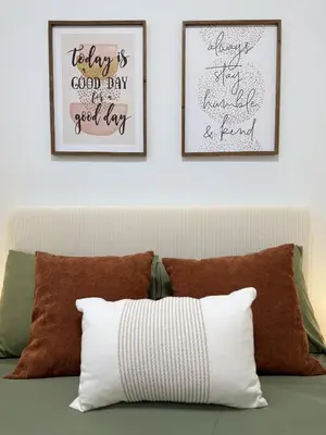 two framed art prints above a couch with pillows at Private 2BR Lake Suite - Chestermere - Sleeps 6 in Chestermere