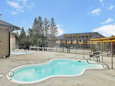 a swimming pool in a yard with a building at Bighorn Meadows Condos by StayIn in Radium Hot Springs