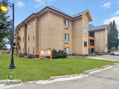 a large building with a sign in front of it at Bighorn Meadows Condos by StayIn in Radium Hot Springs