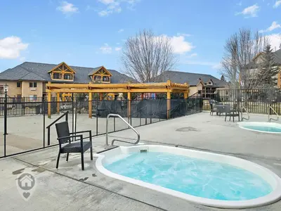 a hot tub in a patio with a house at Bighorn Meadows Condos by StayIn in Radium Hot Springs