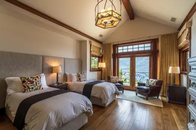 a bedroom with two beds and a chandelier at Chateau Okanagan in Kelowna