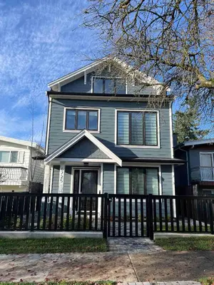 a house with a fence in front of it at SixPine - One bedroom suite in Vancouver