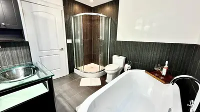 a bathroom with a tub and a toilet and a sink at Emerald 3Bed 1bath Rancher 2C-D EvEs Spa BBQ RKE in Langley