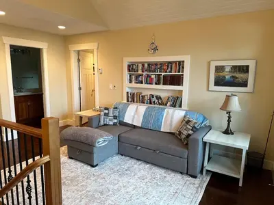 a living room with a couch and a book shelf at Large ocean view family retreat in Comox