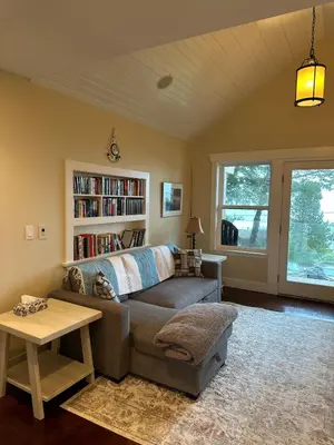 a living room with a couch and a book shelf at Large ocean view family retreat in Comox