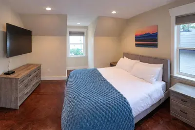 a bedroom with a bed and a flat screen tv at Large ocean view family retreat in Comox