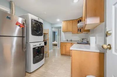 a kitchen with a stainless steel refrigerator and wooden cabinets at Comfortable Westside Vancouver Stay in Vancouver