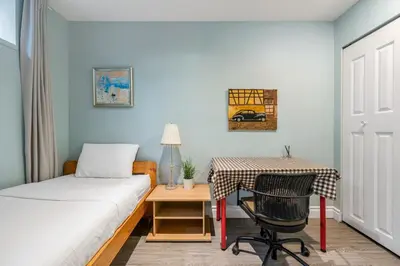 a bedroom with a bed and a table with a chair at Comfortable Westside Vancouver Stay in Vancouver