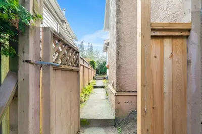 an alley between two buildings with a wooden fence at Comfortable Westside Vancouver Stay in Vancouver