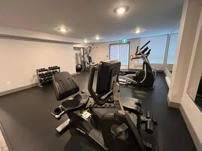 a gym with two treadmills and two exercise bikes at Modern & Stylish Condo in Langley City in Langley