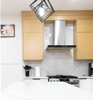 a kitchen with a stove top oven under a light fixture at Elegant Stylish Modern Residence in Vancouver