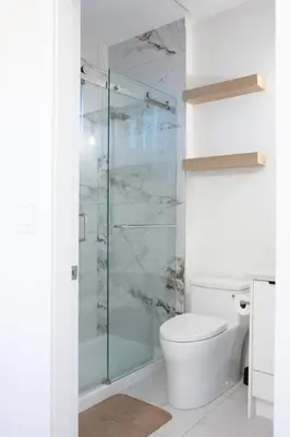 a bathroom with a toilet and a glass shower at Elegant Stylish Modern Residence in Vancouver