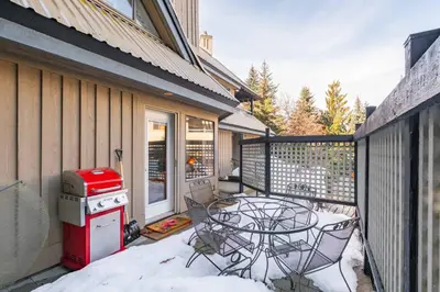 a patio with a table and chairs on a balcony at Foxglove 22 by Outpost Whistler in Whistler