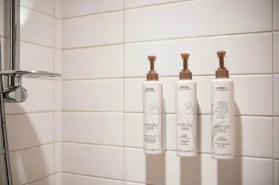 three bottles on a rack in a bathroom at Foxglove 22 by Outpost Whistler in Whistler