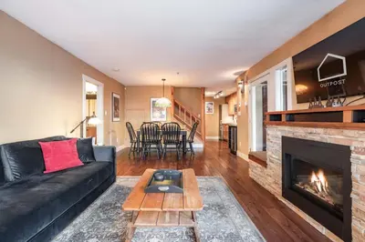 a living room with a black couch and a fireplace at Foxglove 22 by Outpost Whistler in Whistler