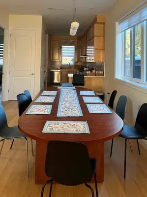 a large wooden table in a kitchen with chairs at SixPine - New 2Br Suite in Vancouver