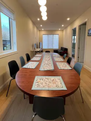 a conference room with a large wooden table and chairs at SixPine - New 2Br Suite in Vancouver
