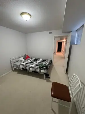 a bedroom with a bed and a chair in a room at Private Room near Scottsdale Shopping Centre in Bélanger