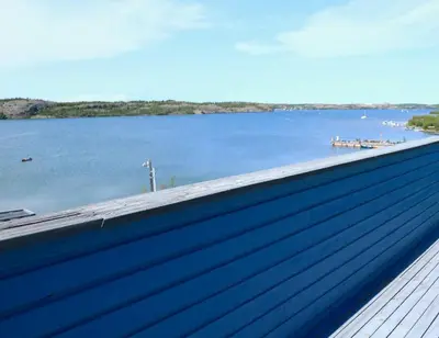 a blue building with a view of a body of water at See Aurora and lake from EVERY room - 2bd 2bth in Yellowknife