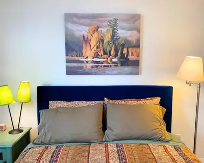 a bedroom with a bed with a painting on the wall at See Aurora and lake from EVERY room - 2bd 2bth in Yellowknife