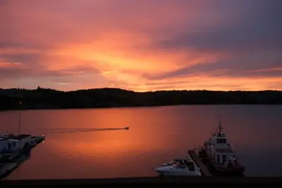 a group of boats on a lake at sunset at See Aurora and lake from EVERY room - 2bd 2bth in Yellowknife