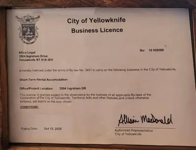 a sign for a city of yellowknife business license at Aurora views from 2 br apartment by lake in Yellowknife