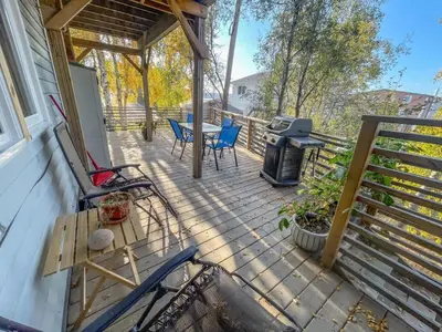 a deck with a table and chairs and a grill at Cozy 1 br apartment in Old Town by lake in Yellowknife