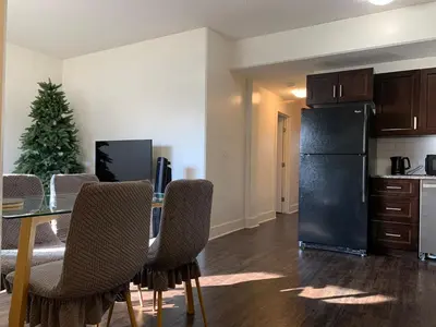 a kitchen with a table and a black refrigerator at Modern 2BR Retreat Near West Edmonton Mall in Edmonton
