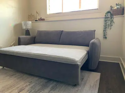 a bed in a living room with a couch at Modern 2BR Retreat Near West Edmonton Mall in Edmonton