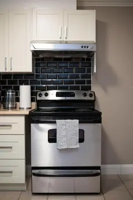 a kitchen with a stove top oven in a kitchen at Modern 2BR Suite | 10 Mins to YVR & Canada Line in Vancouver