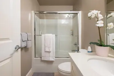 a bathroom with a shower and a toilet and a sink at Modern 2BR Suite | 10 Mins to YVR & Canada Line in Vancouver