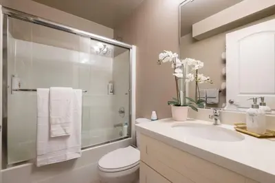 a bathroom with a toilet and a sink and a shower at Modern 2BR Suite | 10 Mins to YVR & Canada Line in Vancouver