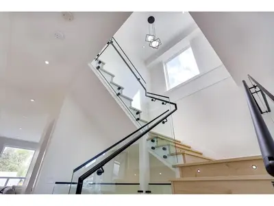 a staircase in a house with a glass railing at BRAND NEW LUXURY 4 Beds 4 baths Home Langley Perfect for Families and Groups in Langley