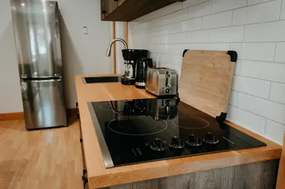 a kitchen with a stove top oven next to a refrigerator at Quadra Island Mist in Quathiaski Cove