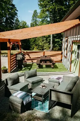 a patio with couches and a table and a grill at Quadra Island Mist in Quathiaski Cove