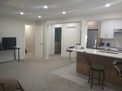 a kitchen with a counter and a chair in a room at Aeropuerto basement in Calgary
