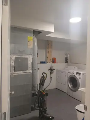 a laundry room with a washing machine and a washer at Aeropuerto basement in Calgary