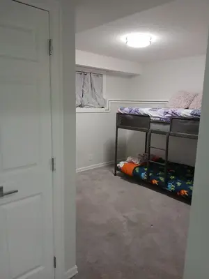 a room with two bunk beds and a hallway at Aeropuerto basement in Calgary