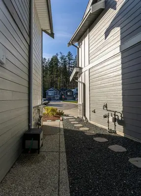 a side view of a building with a driveway at Cozy Corner on Trumpeter in Colwood