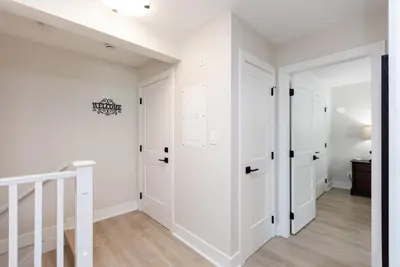 a bedroom with white walls and white closet doors at Cozy Corner on Trumpeter in Colwood