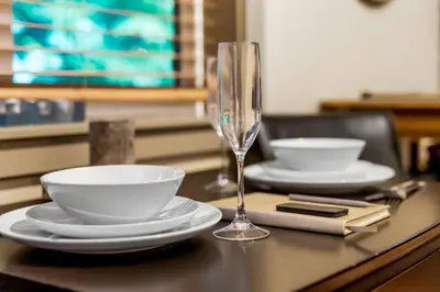 a table with plates and a wine glass on it at JDF Waystation with Bunkhouse - Pet Friendly - sleeps 6 in Port Renfrew