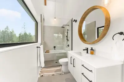 a bathroom with a sink and a toilet and a mirror at Hot Tub & Amazing Ocean View -The Simple Peak - Non pet friendly in Port Renfrew